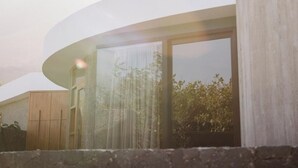 Un bâtiment moderne doté de grandes fenêtres et d’une structure incurvée.