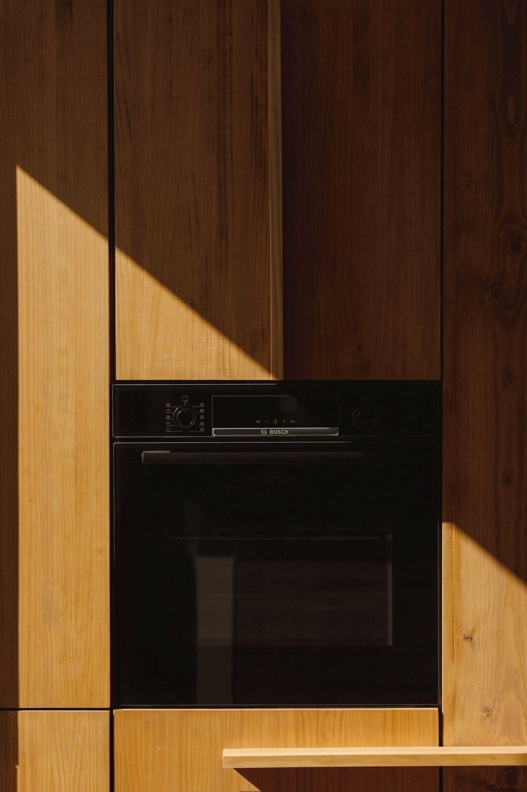 Una cocina moderna con horno empotrado Bosch y armarios de madera.