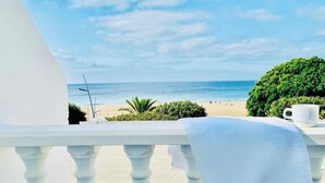 Un balcón con vista a la playa y al océano.