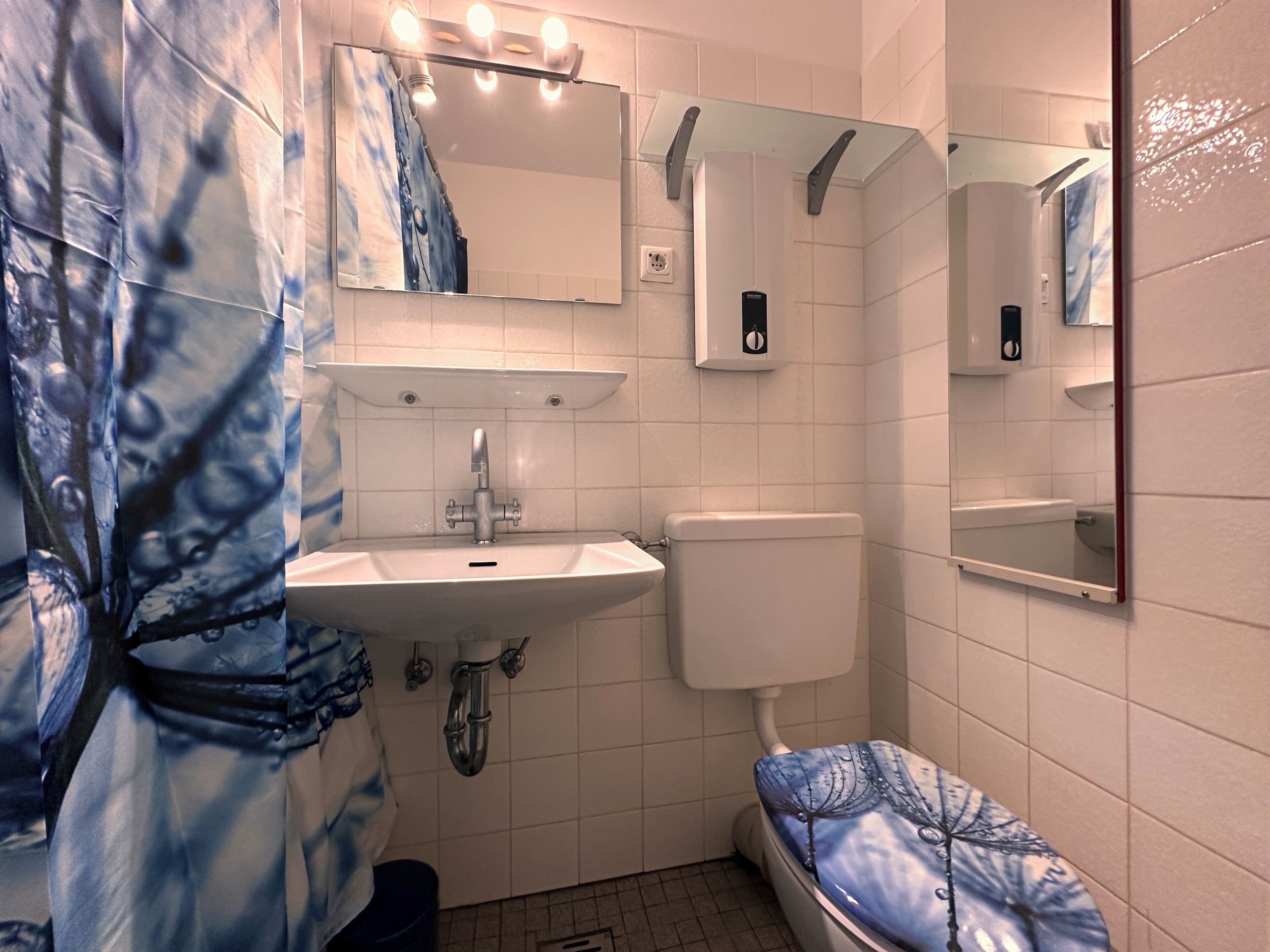 A bathroom with a sink, toilet, and a shower area.