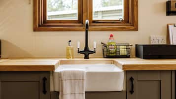 Una cocina con un lavamanos doble, encimeras de madera y una ventana sobre el lavamanos.