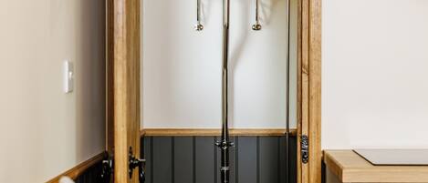 Un baño pequeño con puerta de madera, inodoro, lavabo y un perchero para toallas.