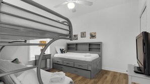 A bedroom with bunk beds, a desk, a chair, a television, and artwork on the wall. - Seagrove 2BR near Lake & Beach + Free Tickets: Bikes, Dolphin Cruise & More! (Santa Rosa Beach)
