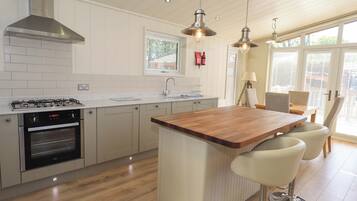 A modern kitchen with a central island, stainless steel appliances, and a large window providing natural light.