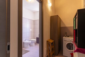 A compact bathroom with a toilet, bidet, and washing machine.