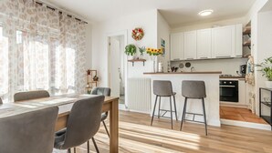 Eine moderne Küche mit weißen Schränken, einer Holzarbeitsplatte und einem eingebauten Backofen.
