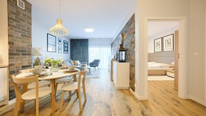 A modern apartment with a dining area, kitchen, and living space. - Apartamenty Sun & Snow Koło Brzegu SPA (Kolobrzeg)