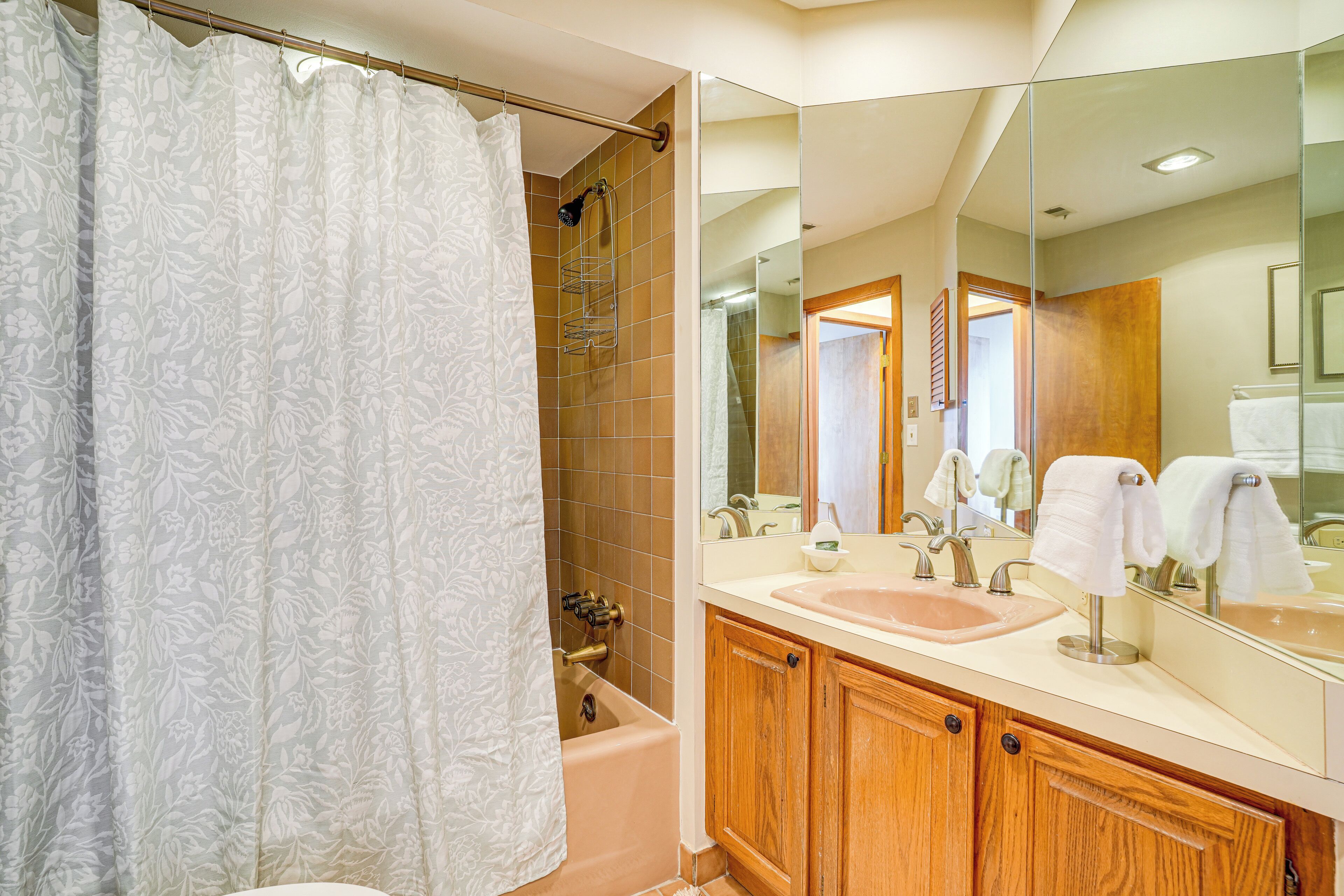 A bathroom with a shower, a sink, and a mirror.