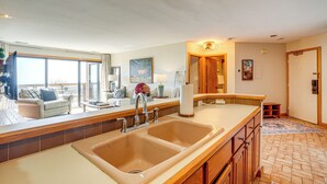 A kitchen with a large sink, wooden cabinets, and a view to the outside. - Pool Access: Scenic Condo in Wintergreen Resort! (Nellysford)
