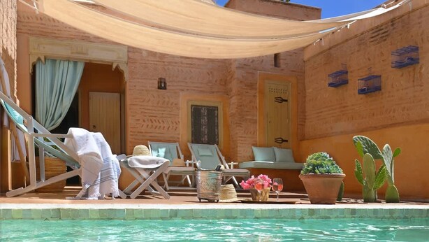 A poolside area with lounge chairs, a small table with drinks, and potted plants. - Charming Mini Riad 2 Bedrooms Shared Pool (Marrakech)