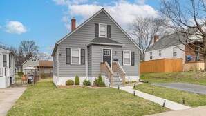 A two-story residential house with a front porch, a small front yard, and a visible staircase leading to the entrance. - 4 Mi to Universities: Quaint Parkville Apartment! (Parkville)