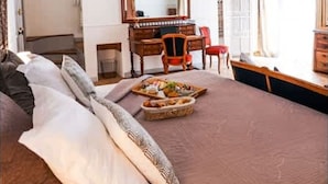 A bedroom with a large bed, a wooden desk, a chair, and a piano. - Proven ale House With Pool and spa (Noves)