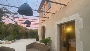 Ένας εξωτερικός χώρος με έπιπλα από μπαμπού και κρεμαστά φωτιστικά.