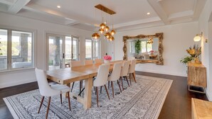 A dining room with a wooden table, white chairs, a patterned rug, and a chandelier. - Outdoor Entertainment Areas: Spacious Katonah Gem! (Katonah)
