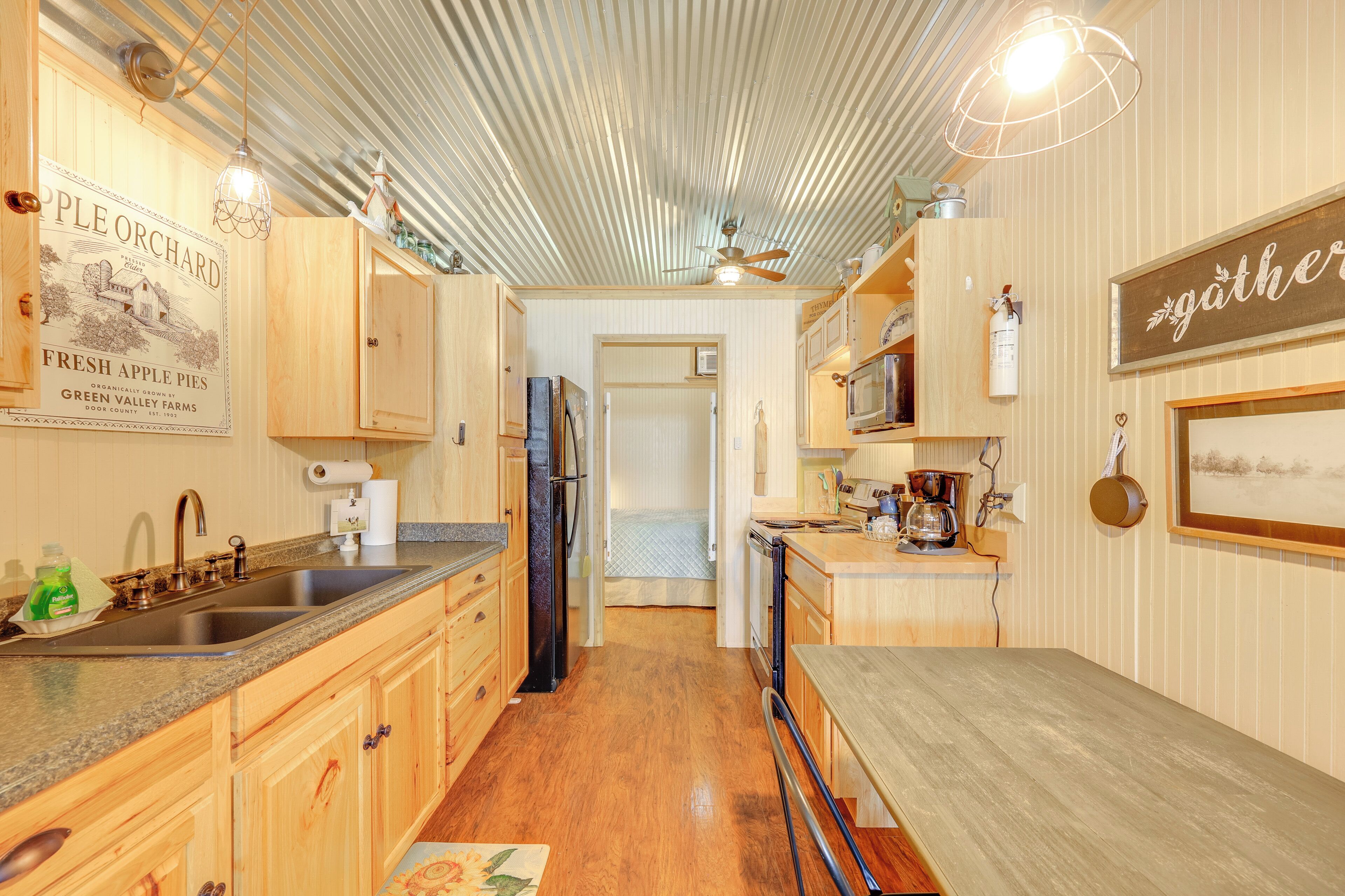 A kitchen with wooden cabinets, a stainless steel sink, and a wooden countertop.