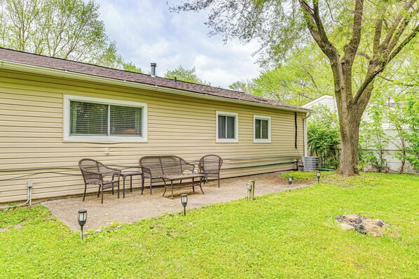 A single-story house with a covered patio area featuring a table and four chairs.