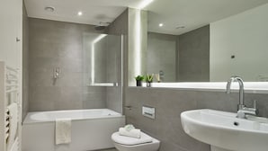 A modern bathroom with a bathtub, toilet, and sink. - Smart Northern Quarter Retreat (Manchester)