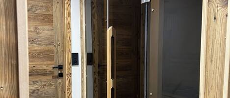 Un pasillo con paredes de madera y una puerta de cristal que da a una habitación.