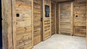 Un couloir aux murs recouverts de lambris en bois et doté d’un sol carrelé.