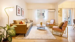 Un salon moderne comprenant un canapé, des fauteuils, une table basse et un lampadaire.