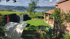 A well-maintained garden with a ping pong table, outdoor seating, and a view of a lake and hills. - Villa T5 Swimming pool with view of Lac du Salagou (Liausson)