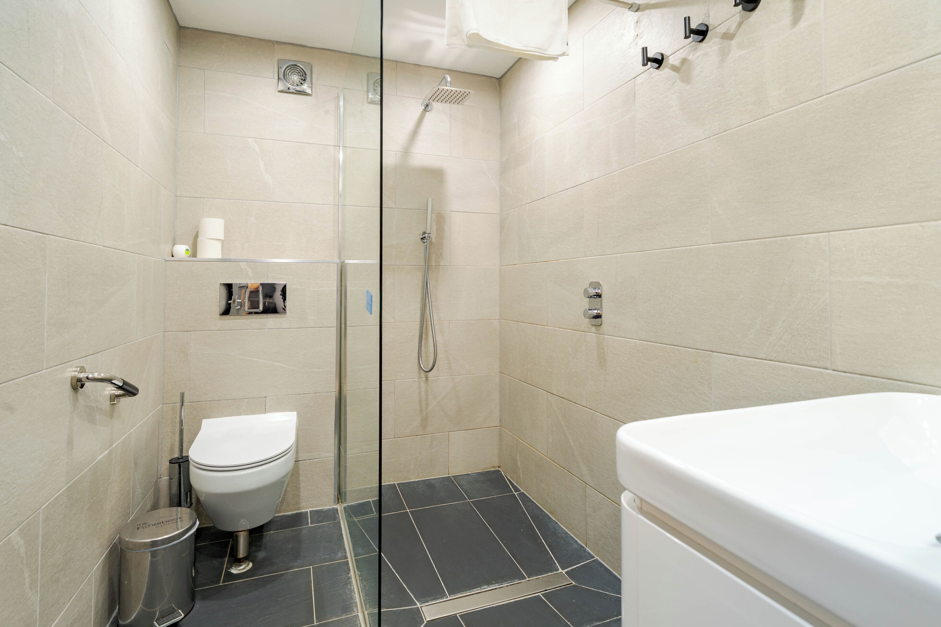 Un baño con ducha, inodoro y lavabo.