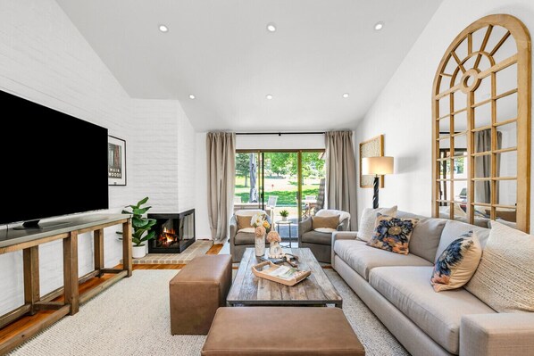 TV connectée, cheminée, livres, écrans d'ordinateur