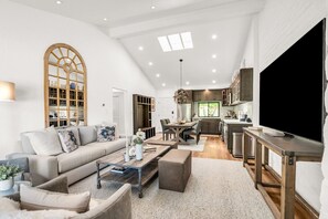 TV connectée, cheminée, livres, écrans d'ordinateur