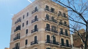 A multi-story building with balconies and storefronts, including a visible 'MINA' sign. - Feel at Sants Apartments (Barcelona)