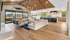 A spacious living area with a large sofa, a coffee table, and a view of the outdoors.