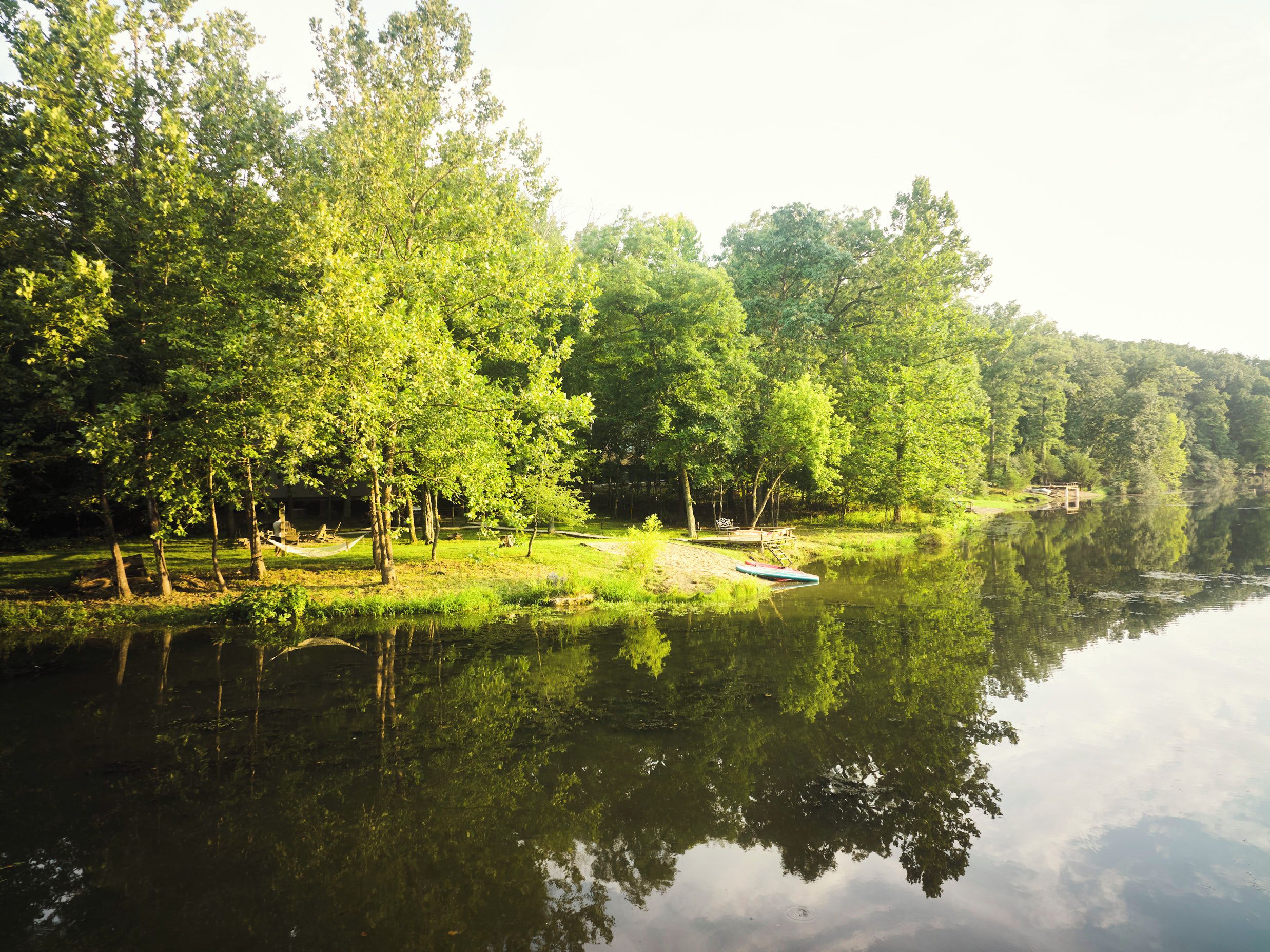 A tranquil lakeside setting with a dock and a small boat.