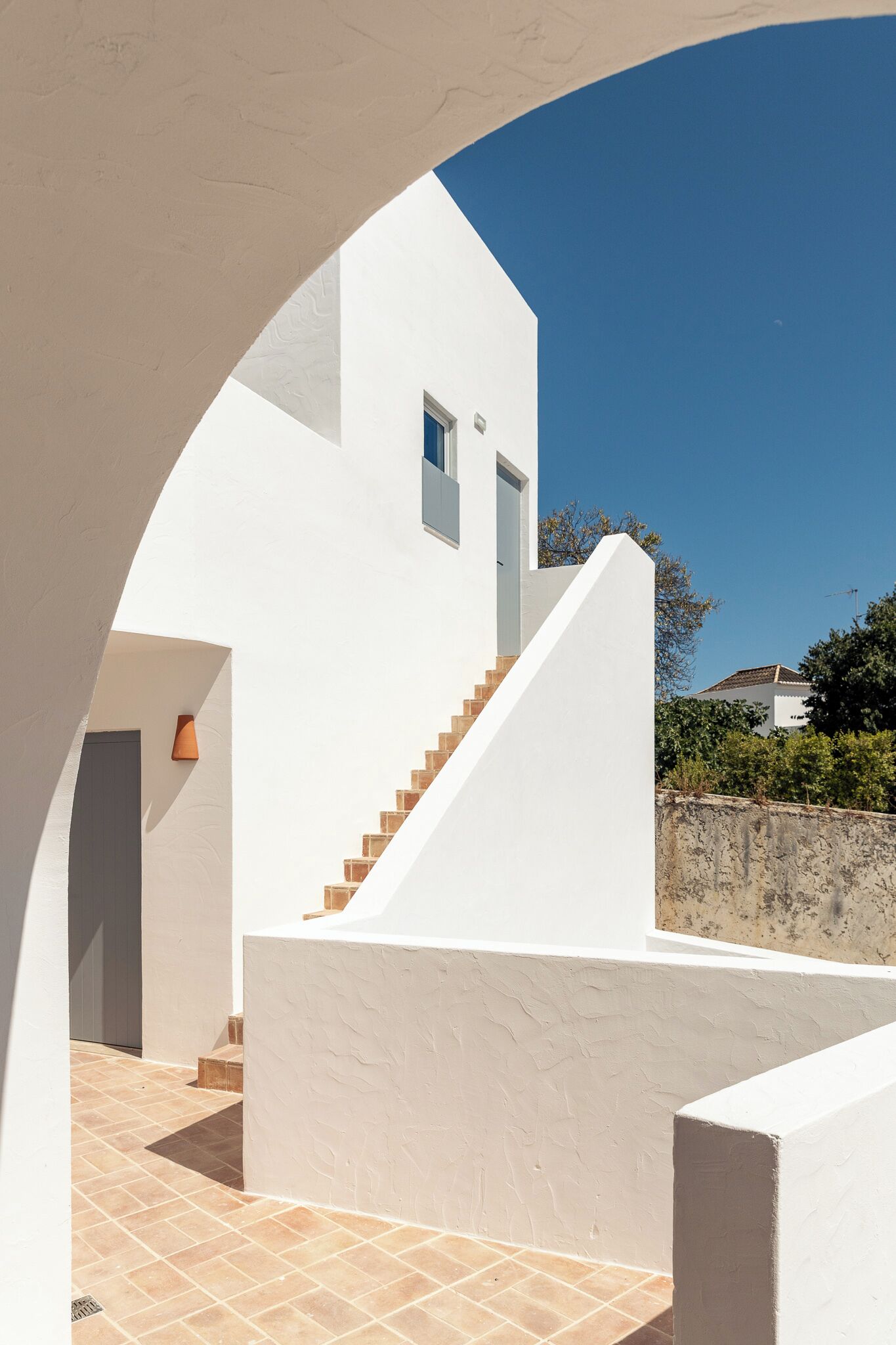 A modern white building with a staircase leading to a second floor.