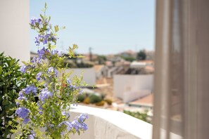 A balcony with a view of a cityscape, featuring a flowering plant. - Palácio de Tavira, a Small Luxury Hotel of the World (Tavira)