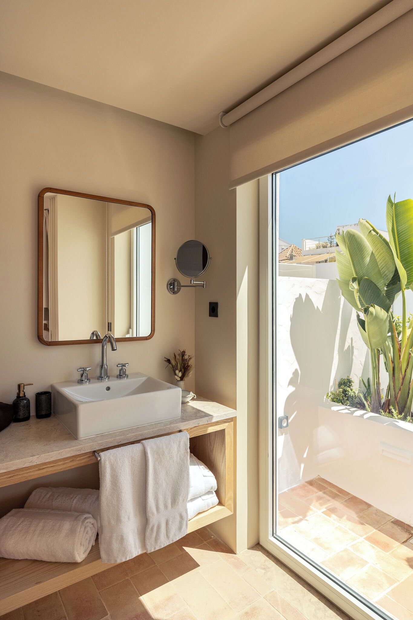 A modern bathroom with a large mirror, a sink, and a towel rack.