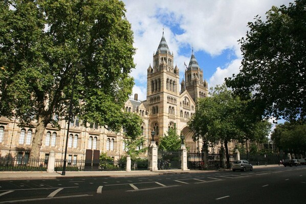 A large, historic building with Gothic architecture, featuring multiple towers and arched windows.