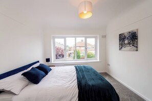A bedroom with a bed, a window, and a painting on the wall. - Hillfoot House (Liverpool)