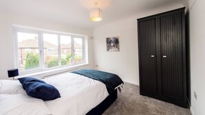 A bedroom with a bed, a window, a wardrobe, and a painting on the wall. - Hillfoot House (Liverpool)