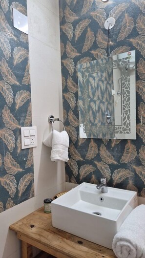 Luxe vierpersoonskamer | Badkamer | Een douche, gratis toiletartikelen, handdoeken, zeep