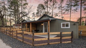 Una cabaña con un porche, una ventana pequeña y un letrero que indica que es propiedad de Shoreline Village Cabins.