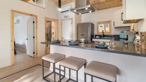 Una cocina moderna con una isla central, techo de madera y electrodomésticos integrados.