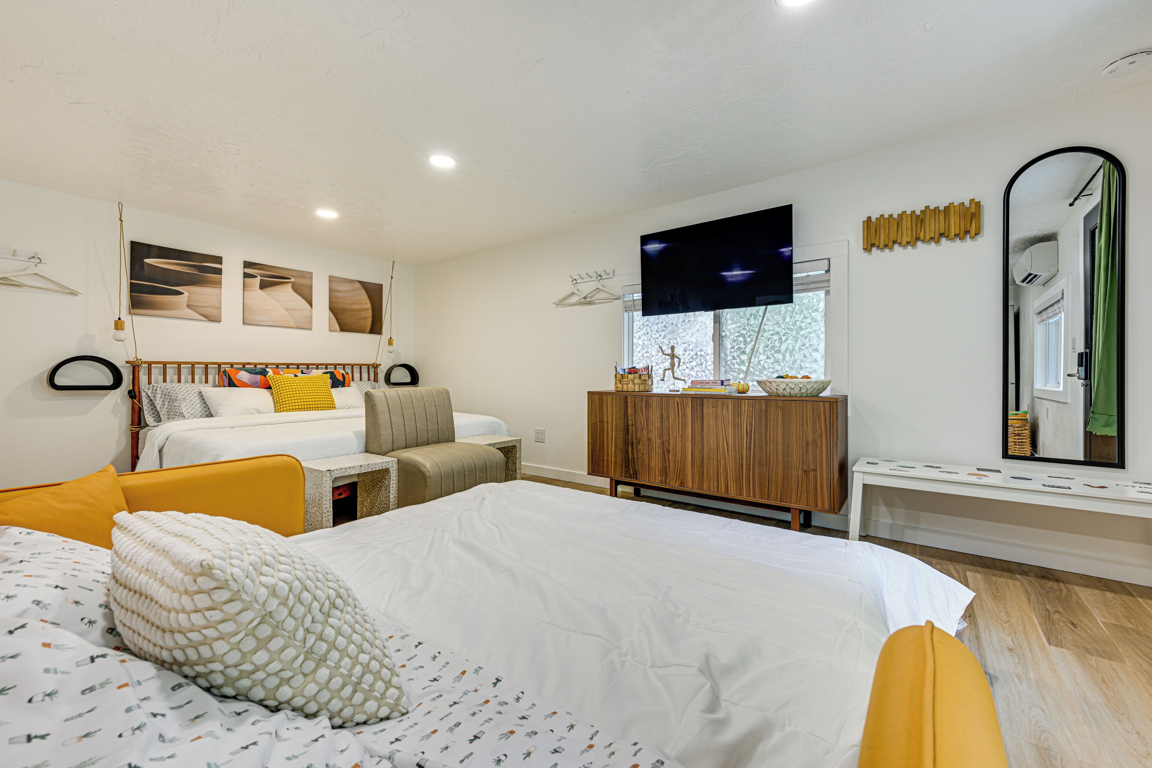 Una habitación de hotel moderna con una cama grande, un escritorio, un armario y un televisor.