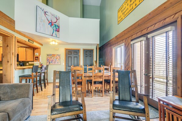 A spacious living area with a dining table, multiple chairs, and a sofa. - 1/2 Mi to Brian Head Resort! Mtn-view Condo (Brian Head)