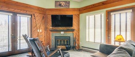A cozy living room with a fireplace, a television, and comfortable seating.