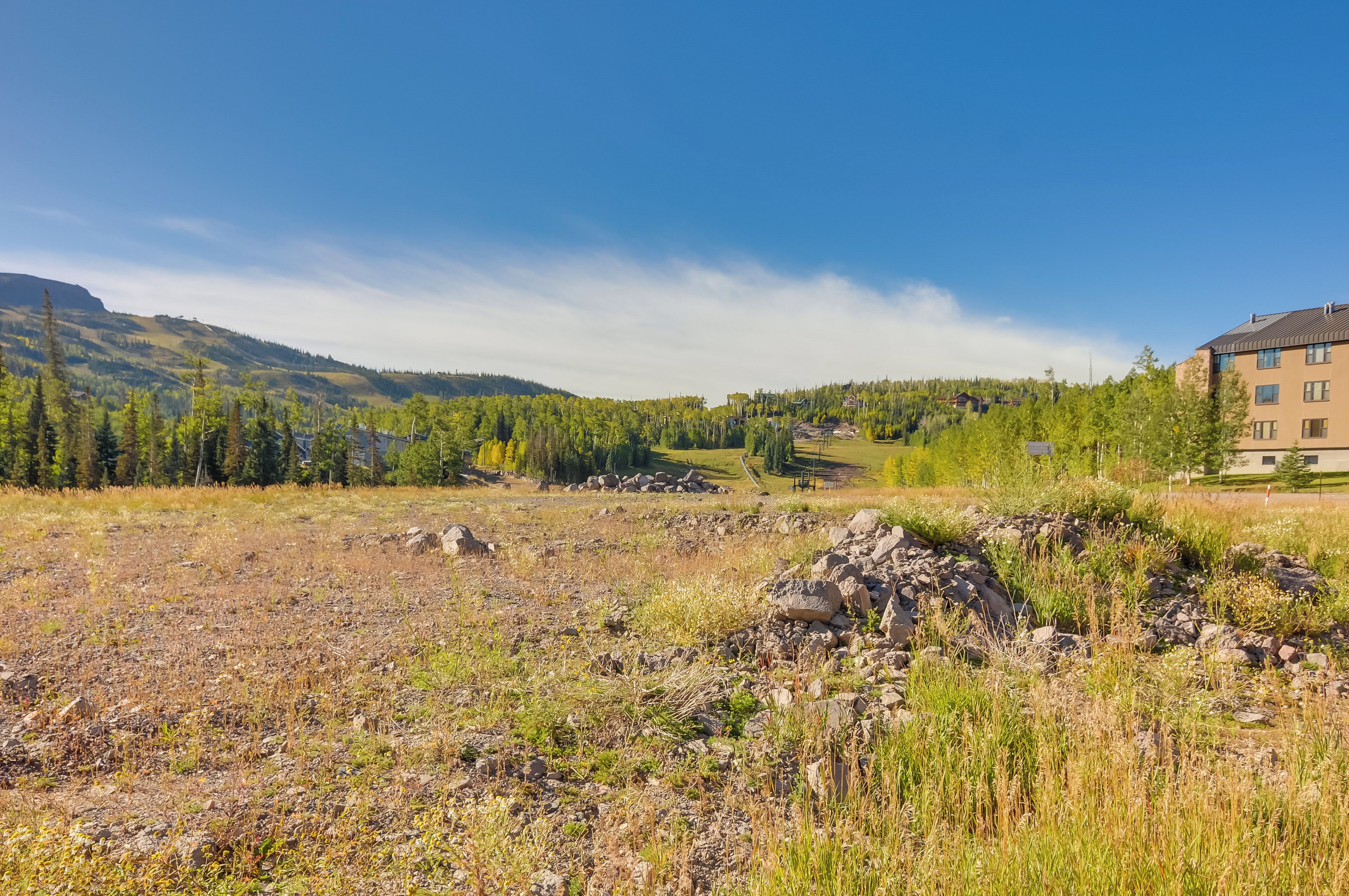 A mountainous landscape with a building in the foreground.