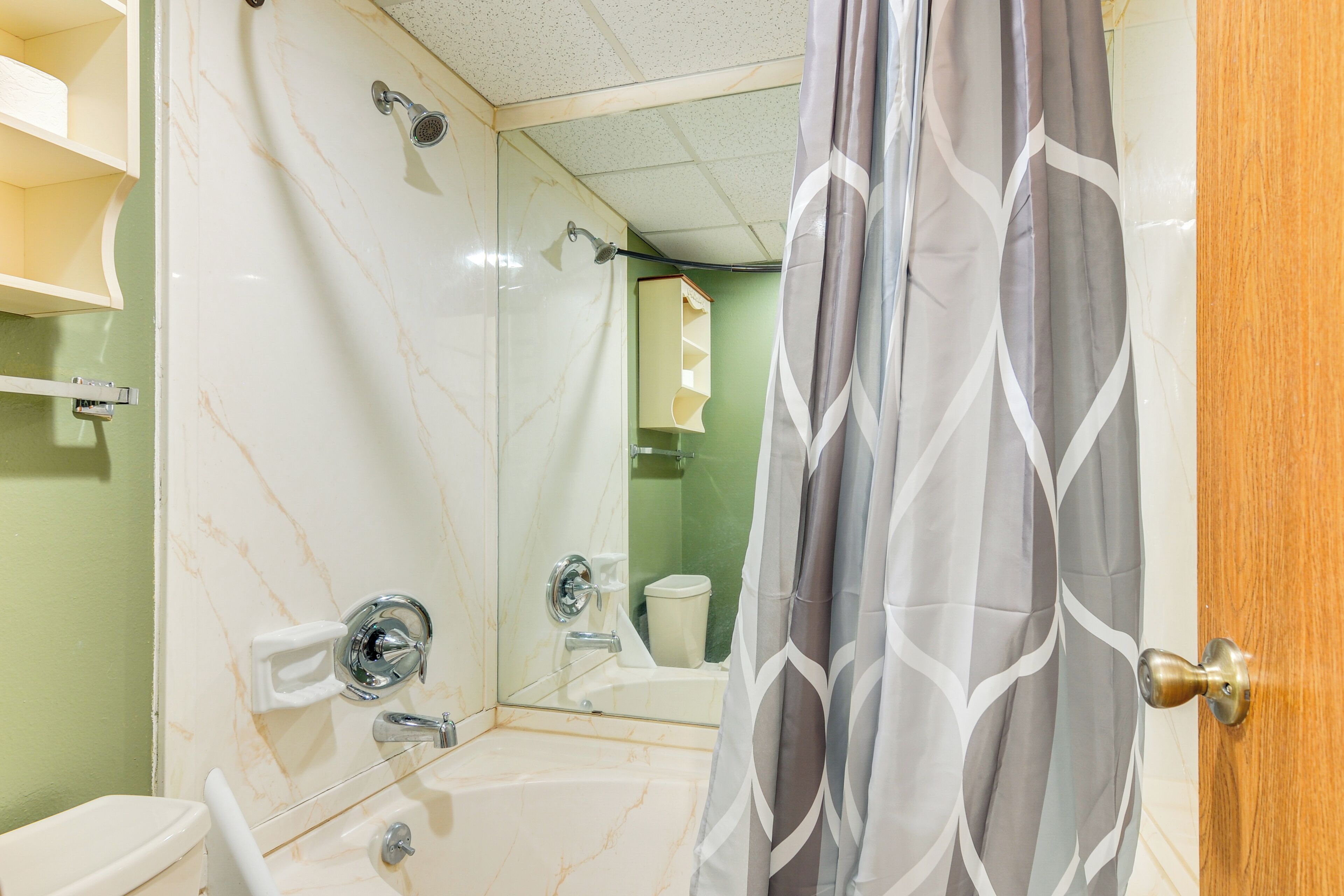 Une salle de bain avec douche, toilettes et lavabo.