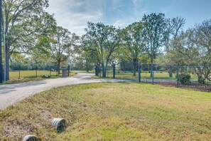 Un espace vert clôturé, agrémenté d’arbres et d’un sentier.