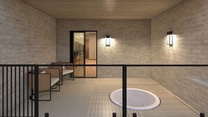 Une salle de bain moderne avec une baignoire sur pieds, une douche à parois de verre et deux appliques murales.