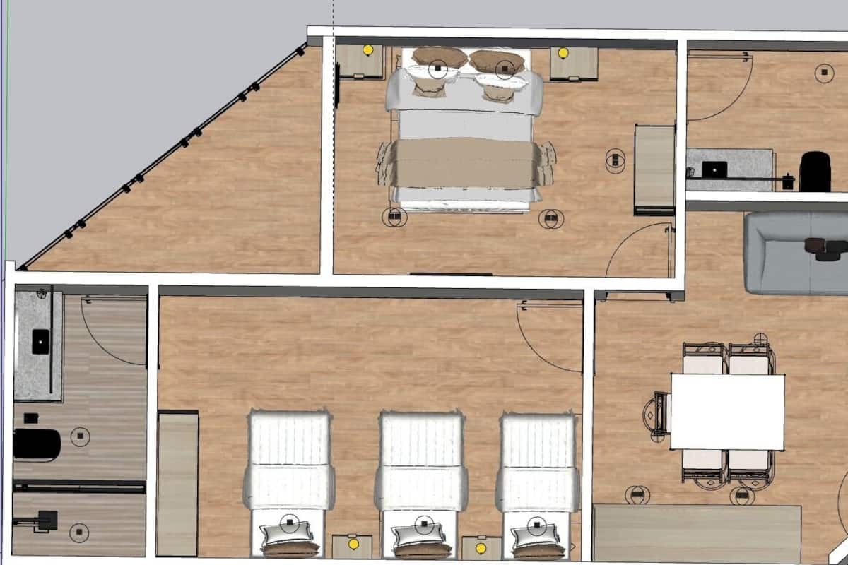 Distribución de una habitación de hotel con cama, escritorio, silla y una pequeña kitchenette.