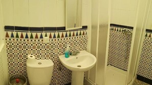 Un baño con inodoro, lavamanos y ducha.