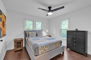 A bedroom with a bed, a dresser, a nightstand, and a ceiling fan. - Relax And Unwind In The Heart Of Fayetteville 2 Bedroom Home (Fayetteville)